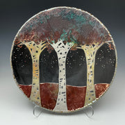 A round ceramic plate with Aspen trees and stars on it