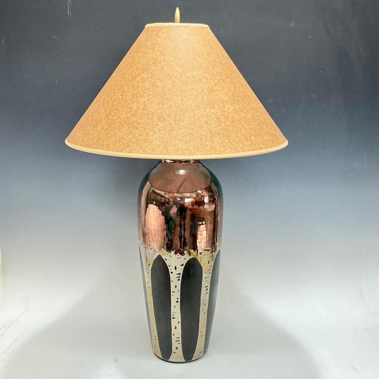 Table lamp with aspen trees and beige shade on a gray background