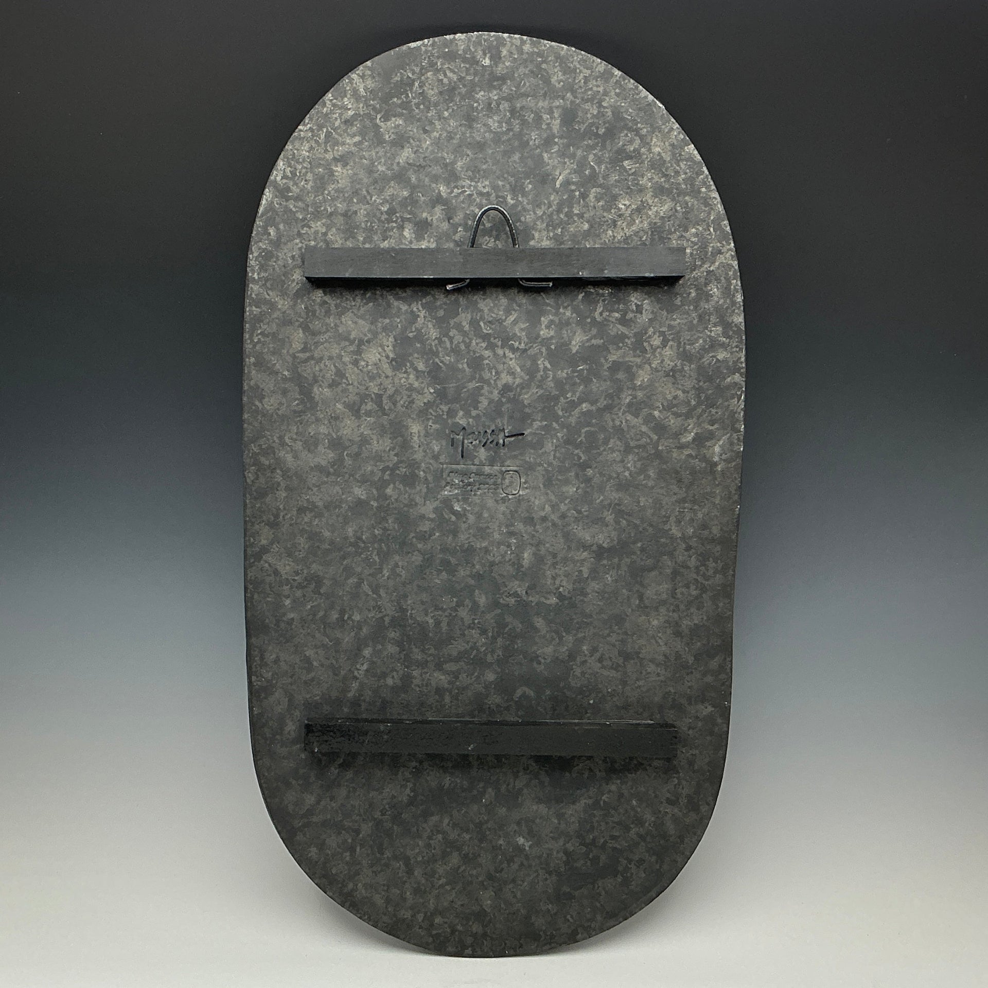 Dark gray stone wall art piece with a subtle pattern on a gradient background