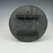 Back of the round wall tile showing the hanger
