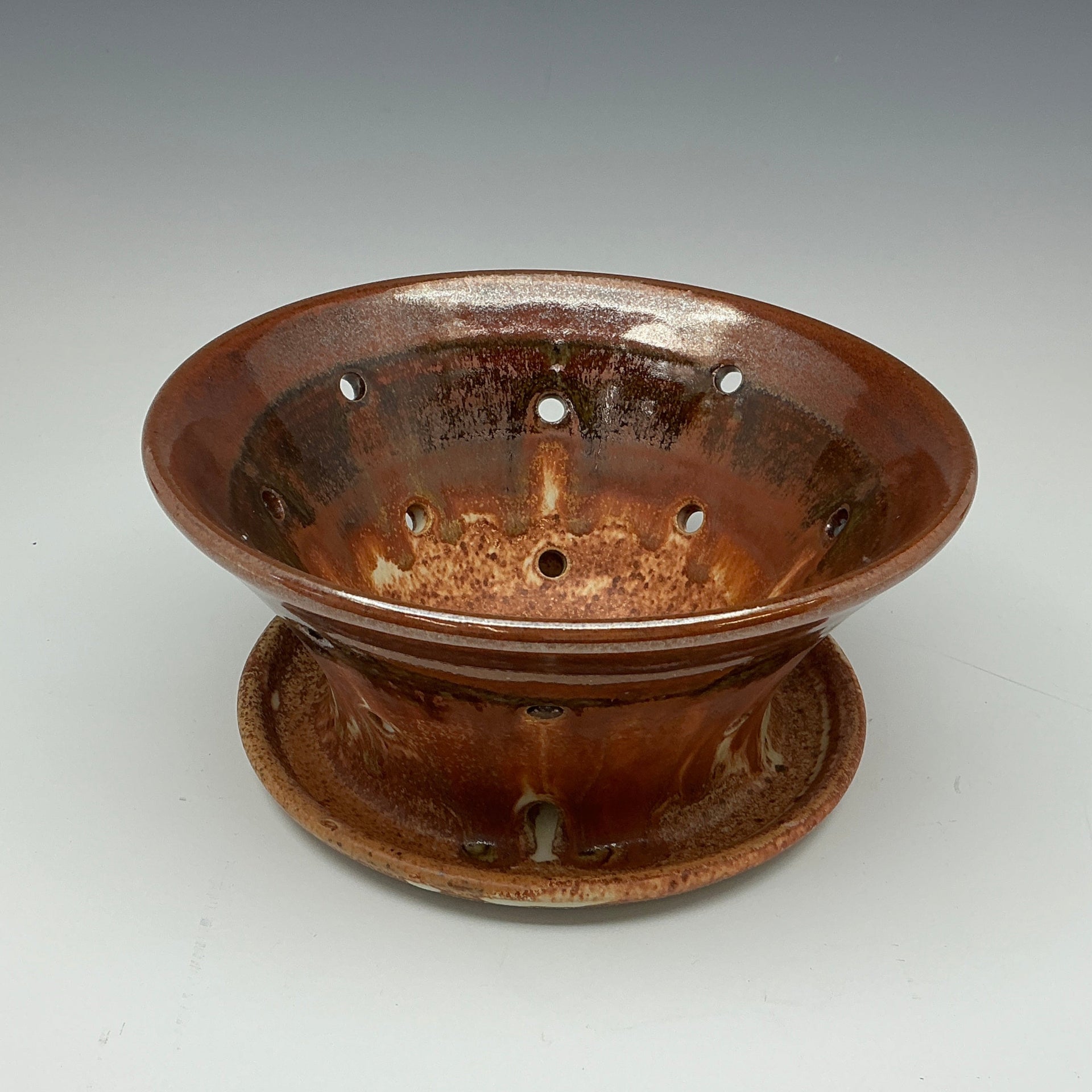 Brown ceramic incense holder on a white background