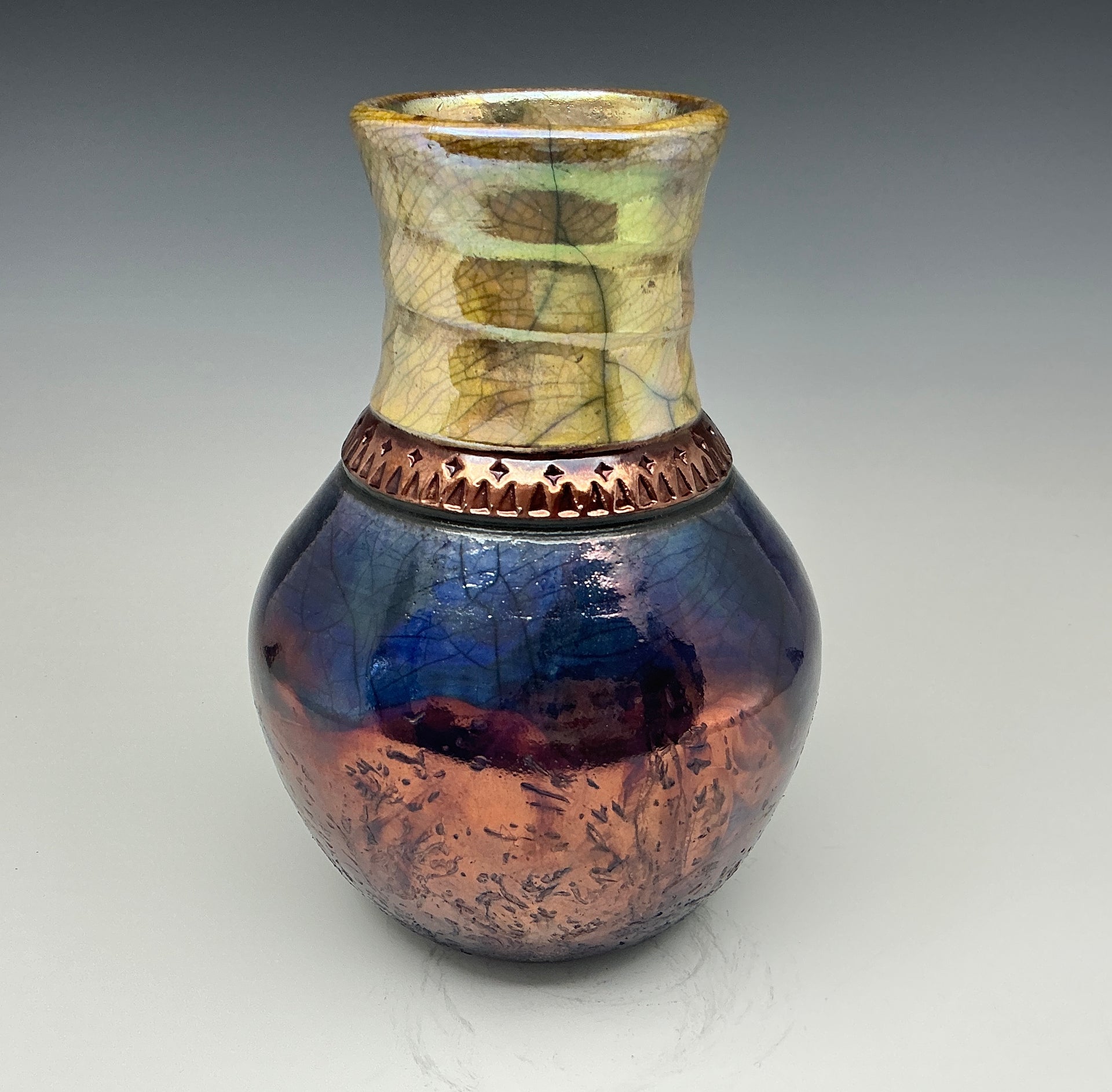 Blue and gold bottle with a copper necklace