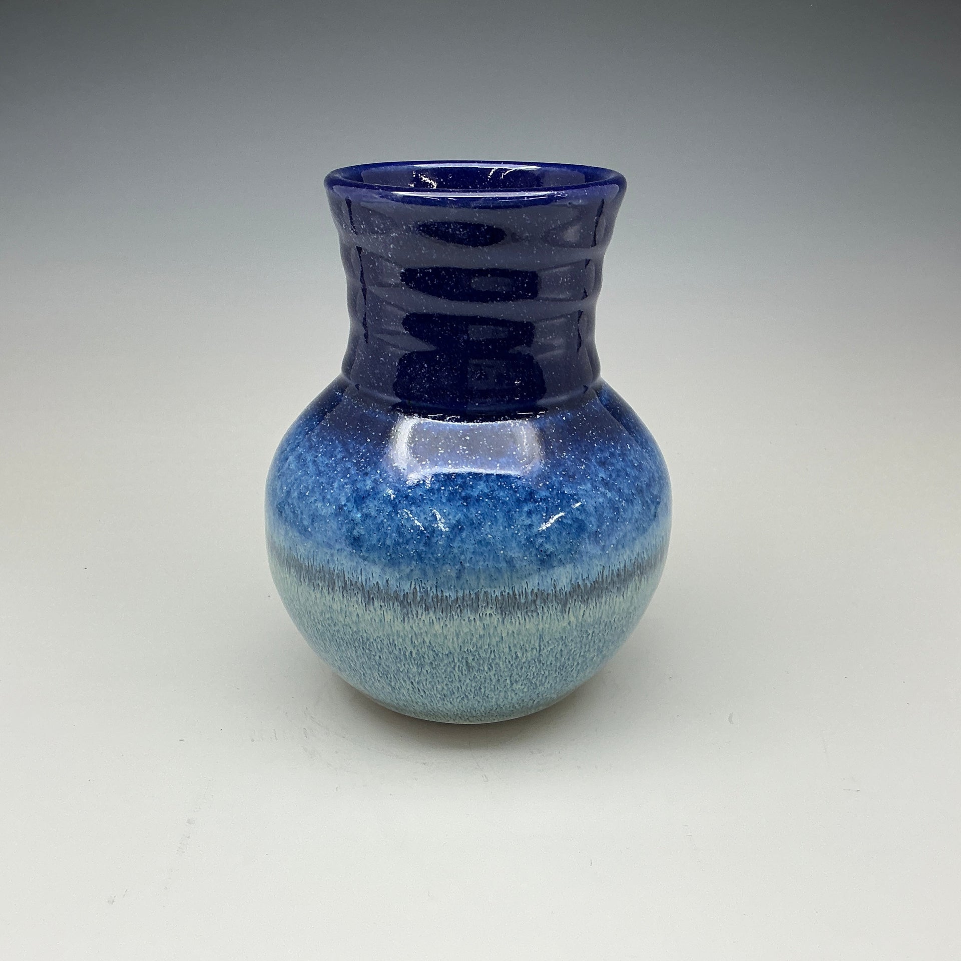 Blue ceramic vase on a gray background