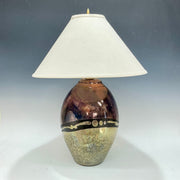 Table lamp with a decorative ceramic base and white shade on a gray background