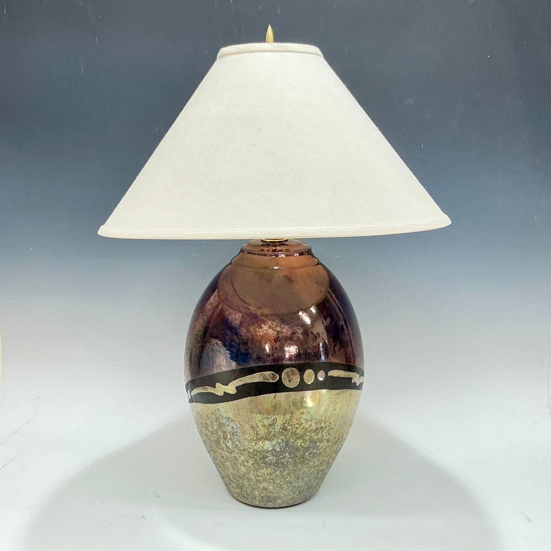 Table lamp with a decorative ceramic base and white shade on a gray background