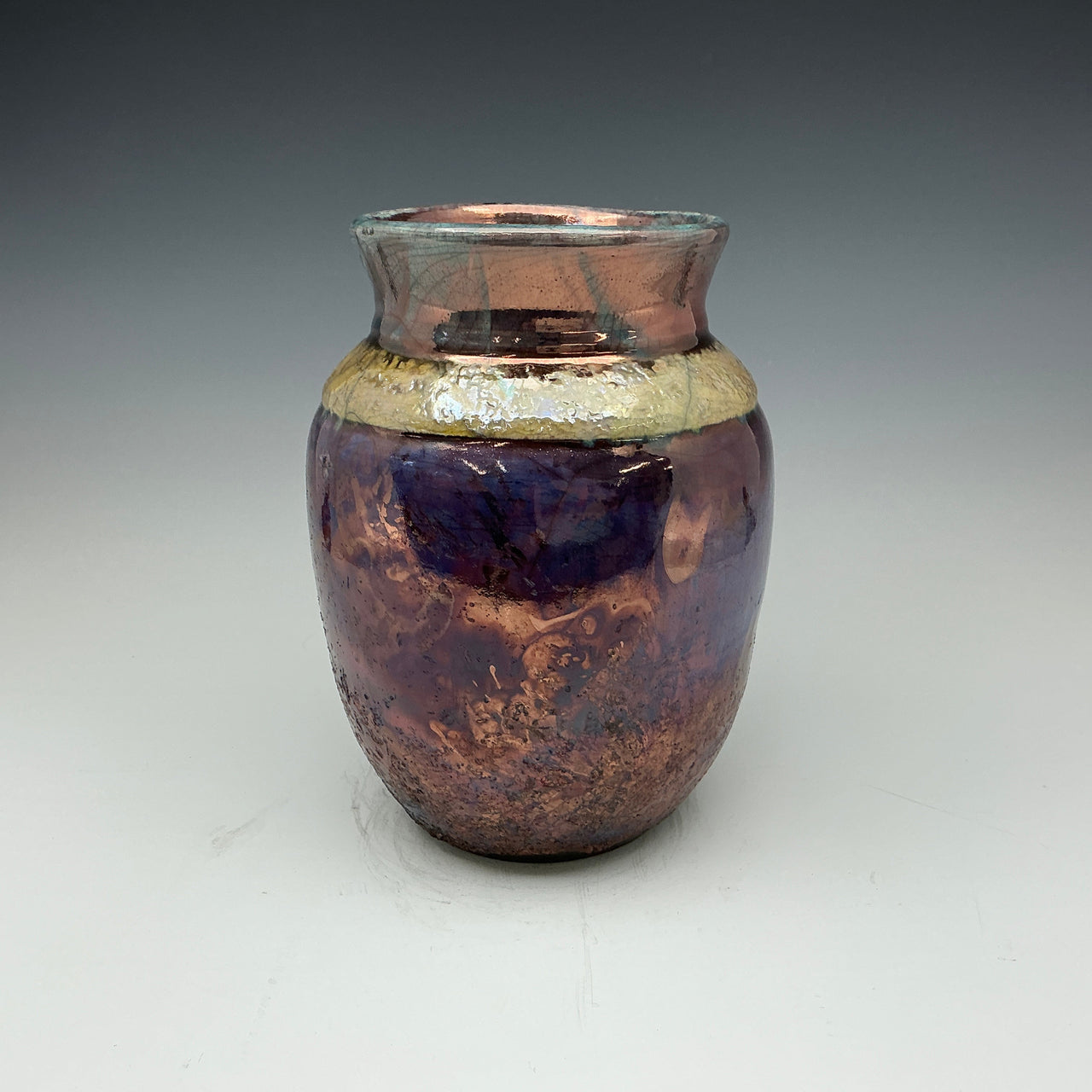 raku vase with blue, gold and teal colors 