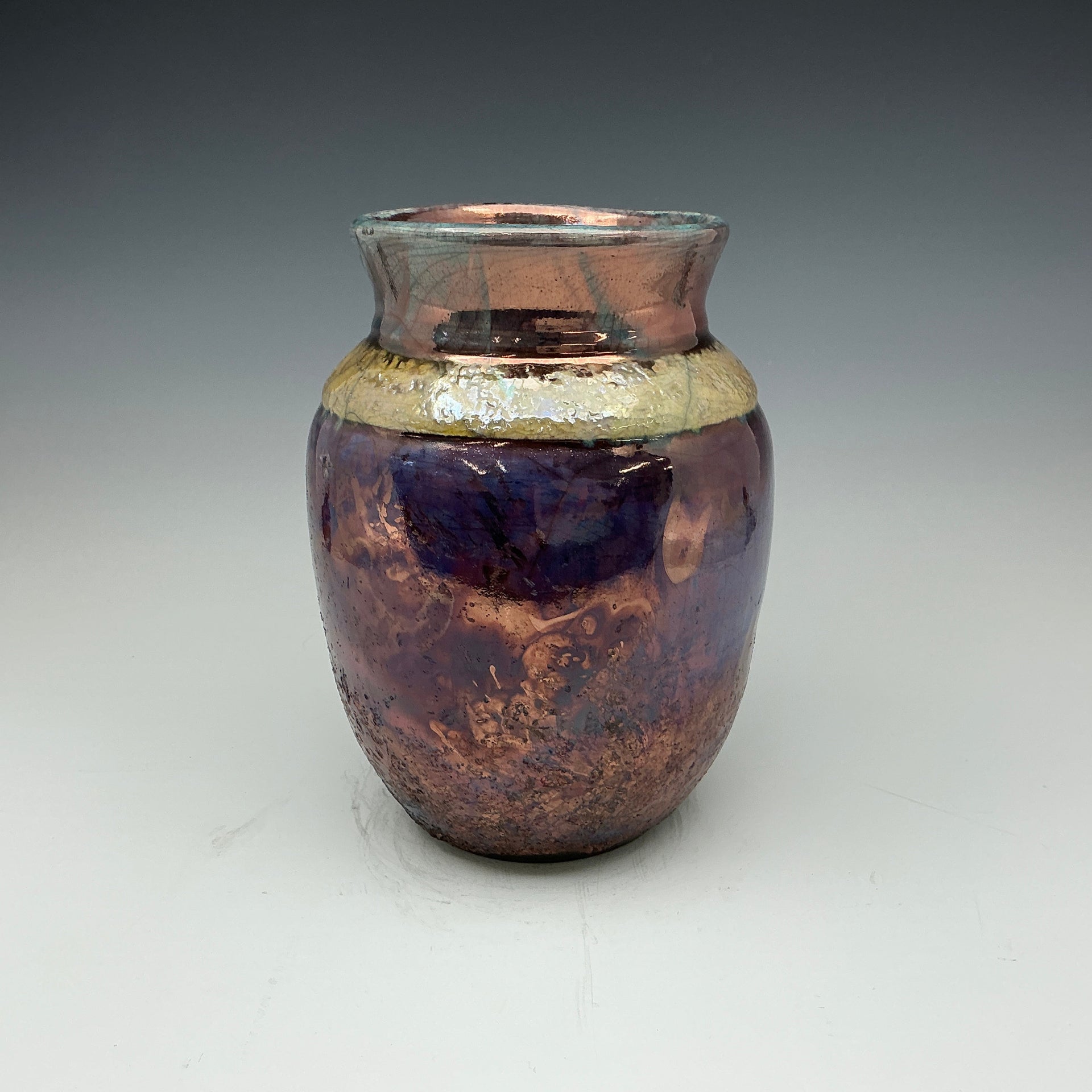 raku vase with blue, gold and teal colors 