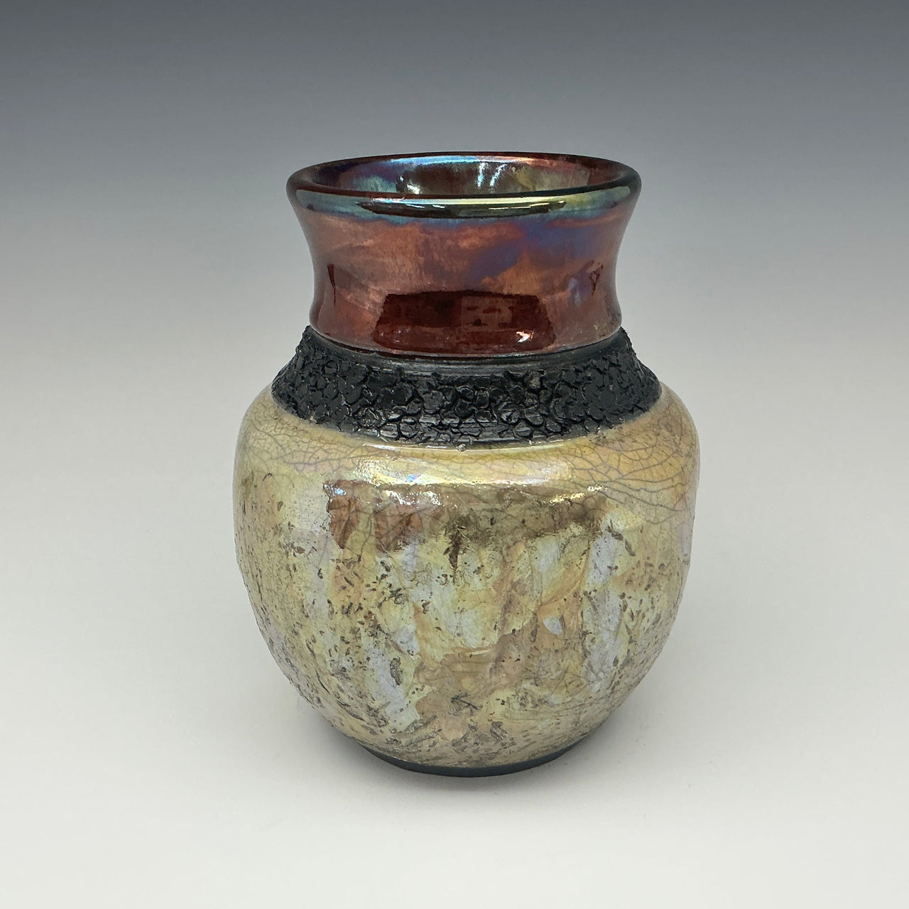 Ceramic vase with textured surface and metallic top on a gradient background