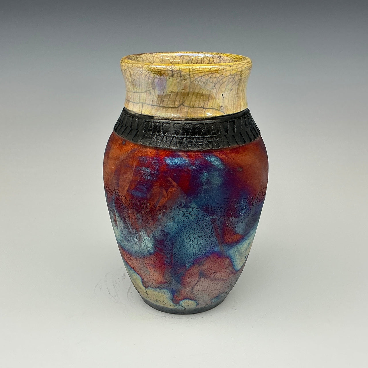 Ceramic vase with multicolored glaze on a gray background