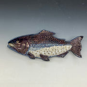 Decorative fish sculpture on a gray background