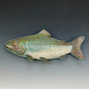 Ceramic fish sculpture on a gradient gray background