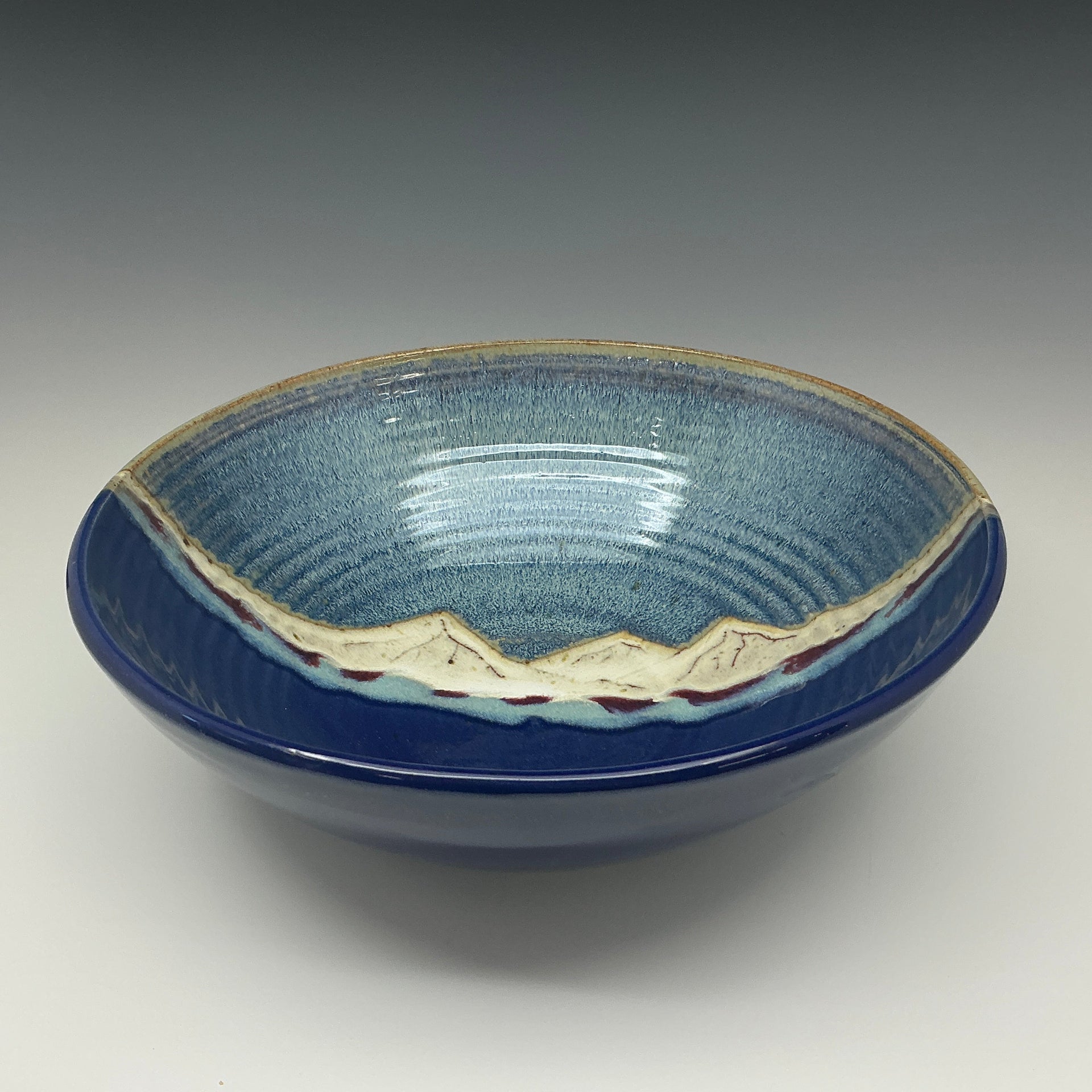 Large ceramic bowl with a mountain on a grey background