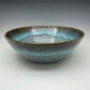 Ceramic bowl with blue and black glaze on a gray background