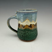 large mug in green and blue with a mountain on it.