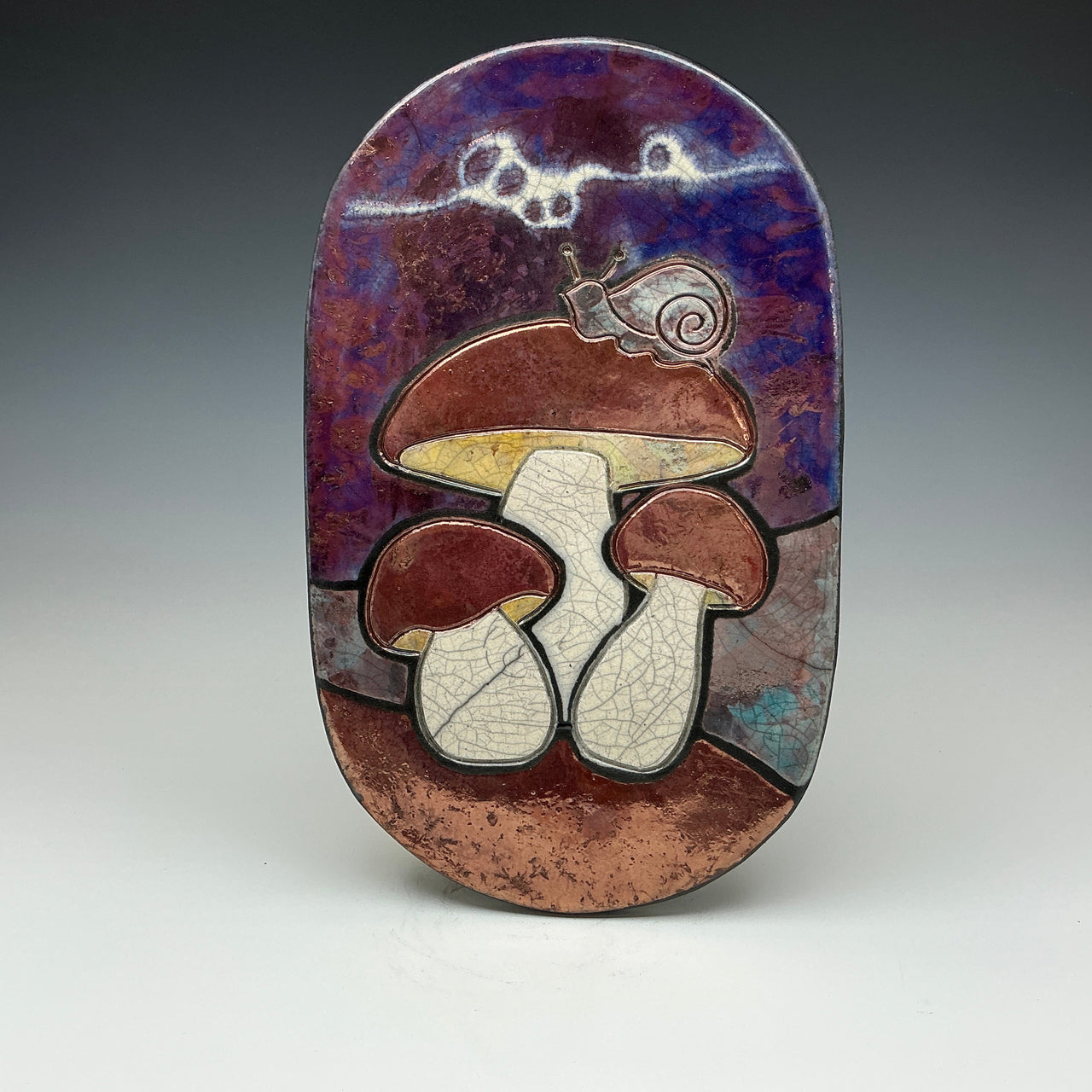 Decorative plate with mushroom design on a purple and brown background