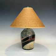 Table lamp with a ceramic base and beige lampshade on a gray background