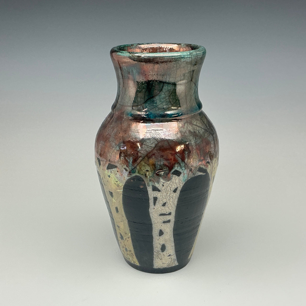 Ceramic vase with multicolored glaze on a gray background