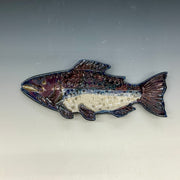 Decorative fish-shaped object on a gray background