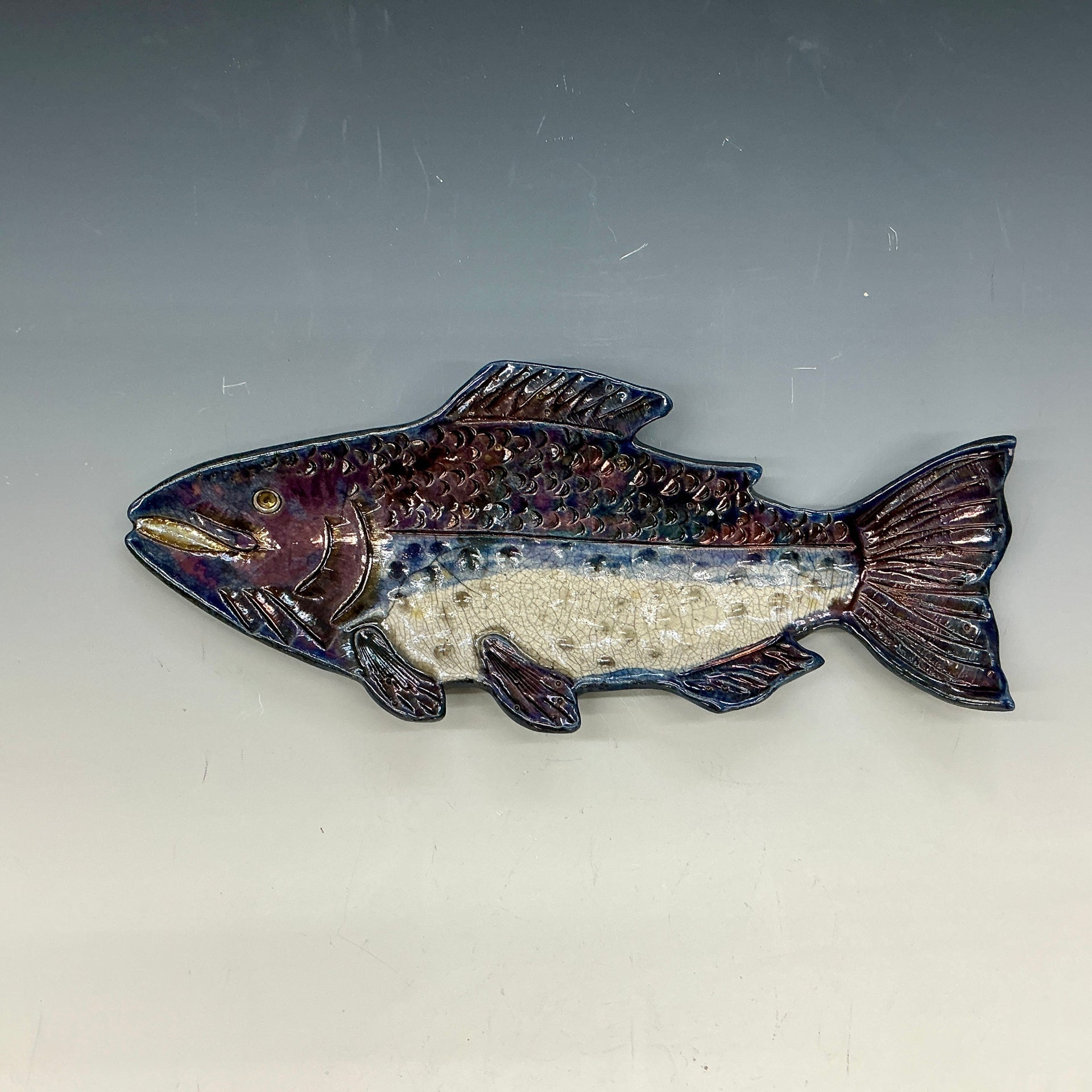 Decorative fish-shaped object on a gray background