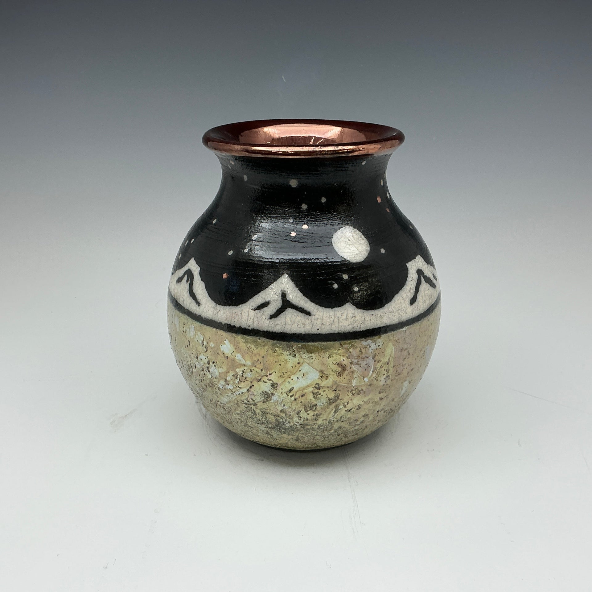 raku vase with mountains and a starry sky, with a gold bottom 
