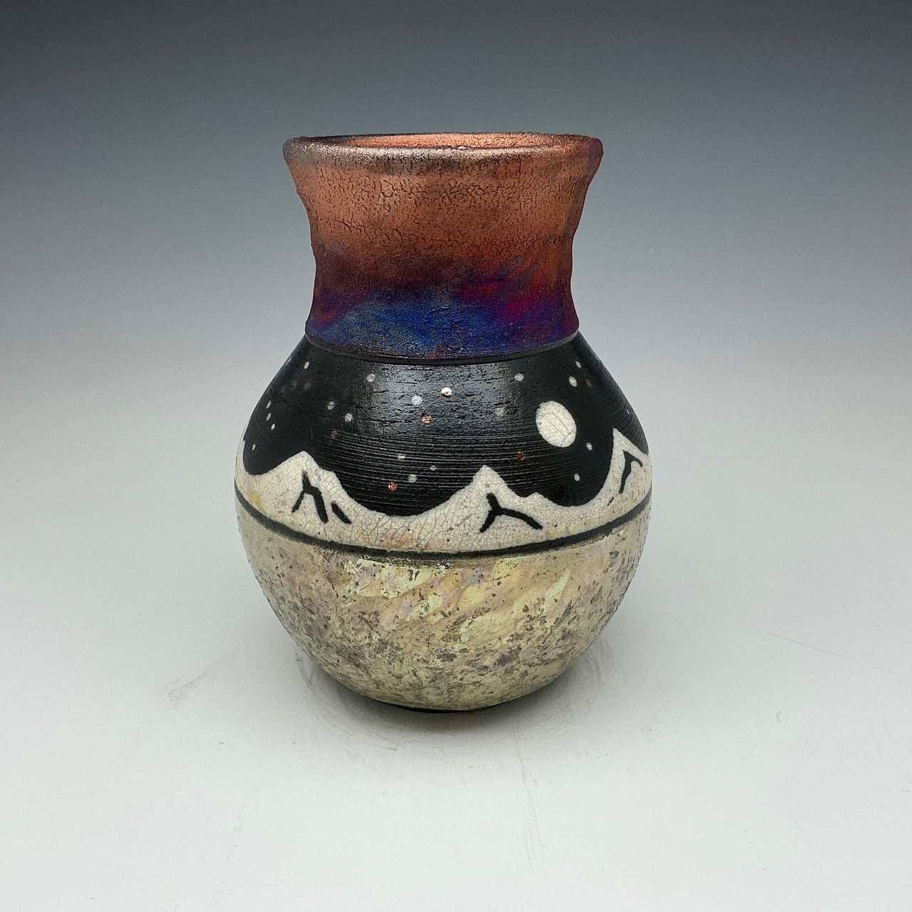 raku vase with white mountains and a starry sky.  