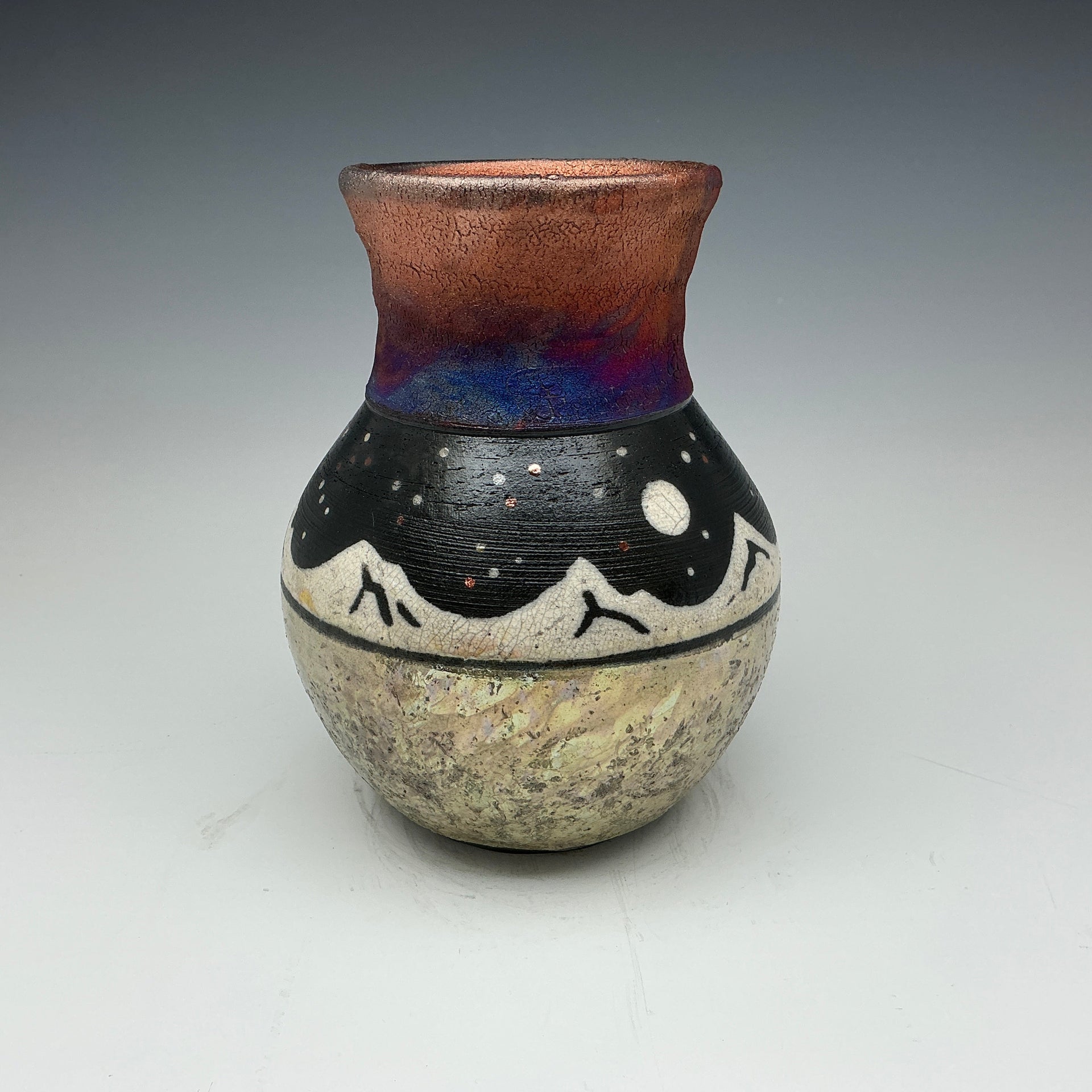 raku vase with white mountains and a starry sky.  