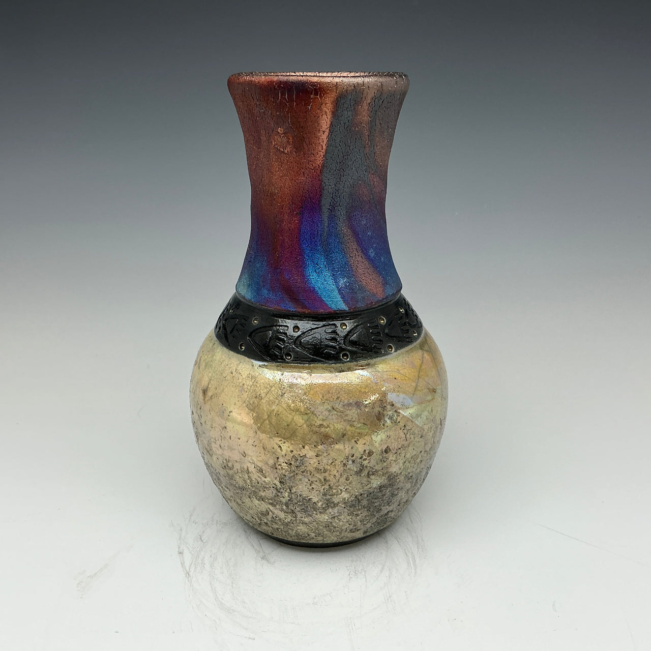 raku vase with a multicolored top and gold bottom with a necklace of black bear prints