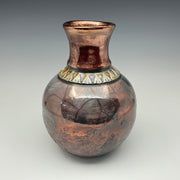 Teal and copper bottle with a gold necklace