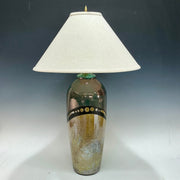 Decorative lamp with a textured base and white shade on a gradient background